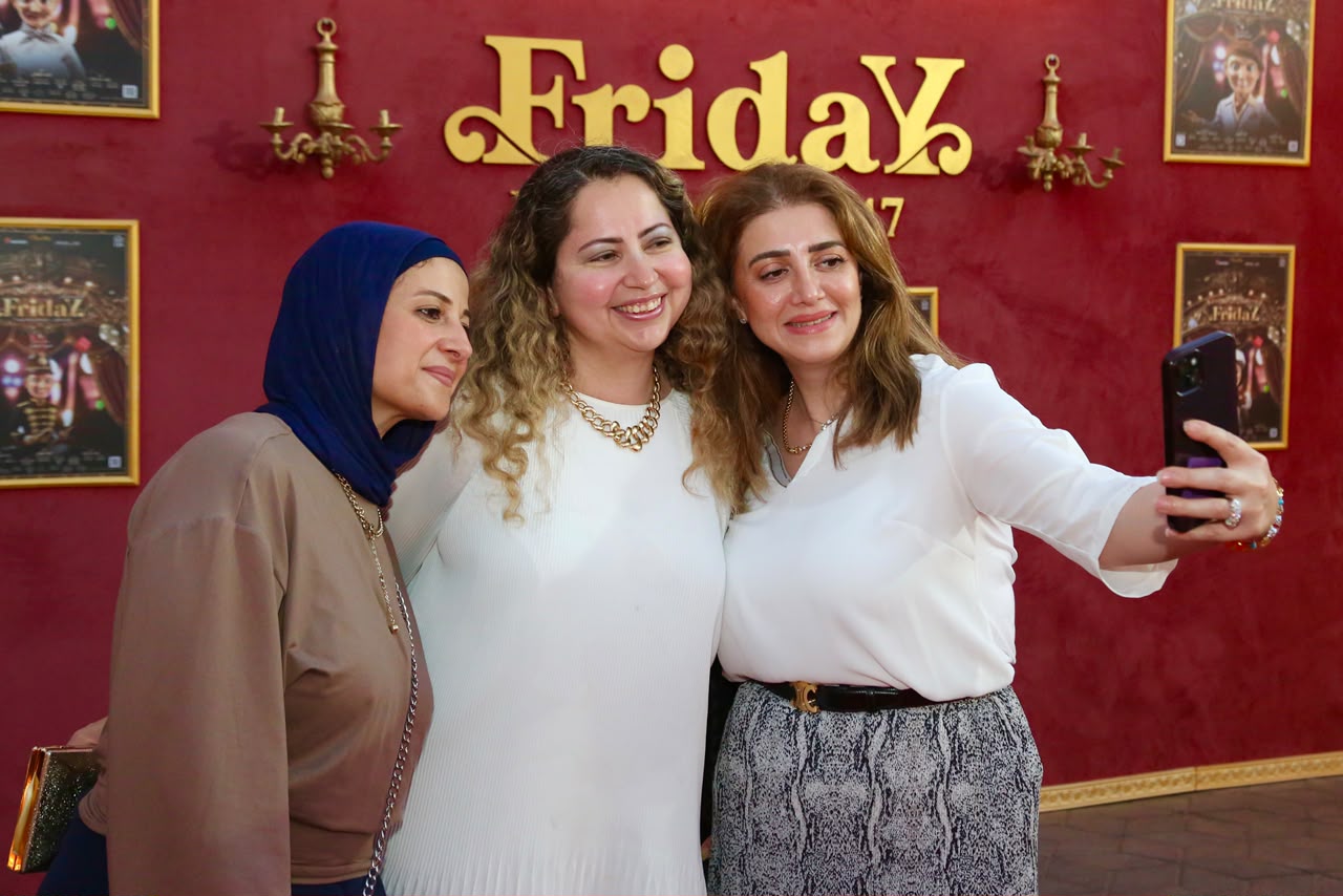 الجمهور يلتقط الصور التذكارية في مدخل المسرح