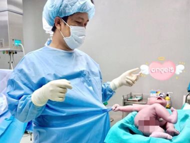 طفل حديث الولادة يمسك ملابس الدكتور